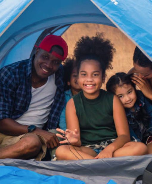 african american family, parent with kids, and asian adoped child having fun together in camping at natural park